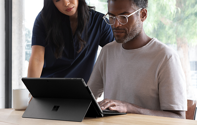 Rask lading En mann og en dame som jobber på en Surface Pro