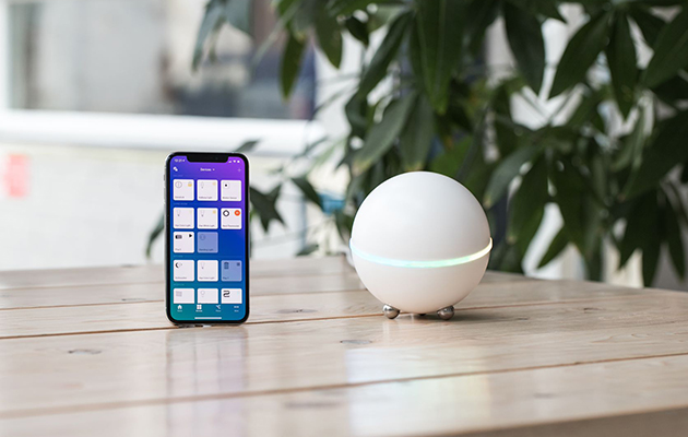 Med Flows kan du lage regler som automatiserer lys, temperatur, TV, høyttalere og internettjenester Bilde av Homeys mobilapp og en Homey på et bord