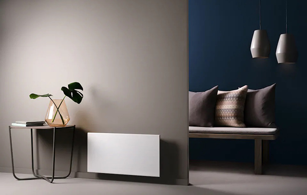 Hold styr på oppvarmingen fra avstand En hvit panelovn på en brun vegg i et minimalistisk dekorert rom