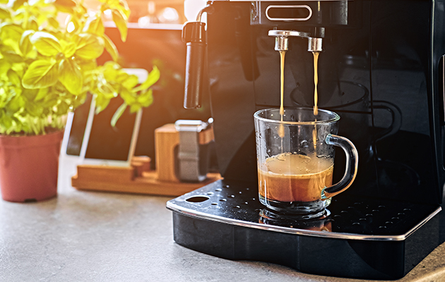 Få kaffe med talekommandoer En kafffekopp som blir fylt med kaffe fra en automatisk kaffemaskin.