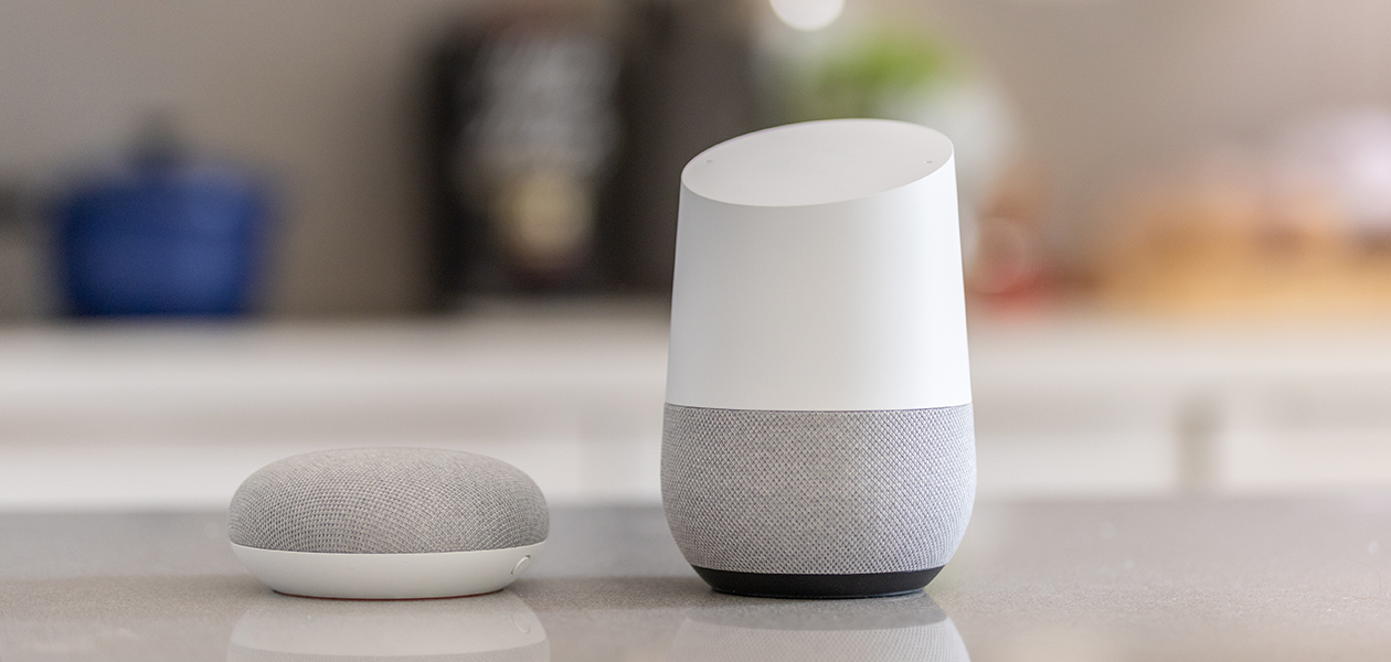 Google Home kan hjelpe deg å lage handlelister En Google Home høyttaler ved siden av en Google Home Mini høyttaler