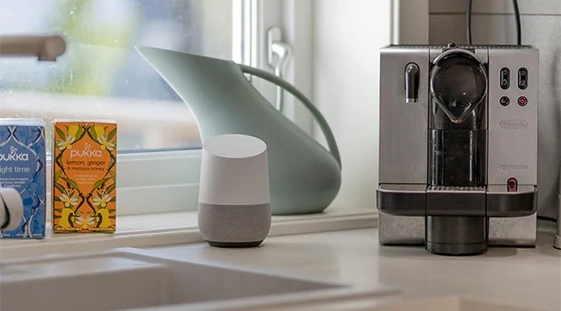 Legg til flere produkter på en gang En Google Home høyttaler på en kjøkkenbenk sammen med pakker med te og en trakter