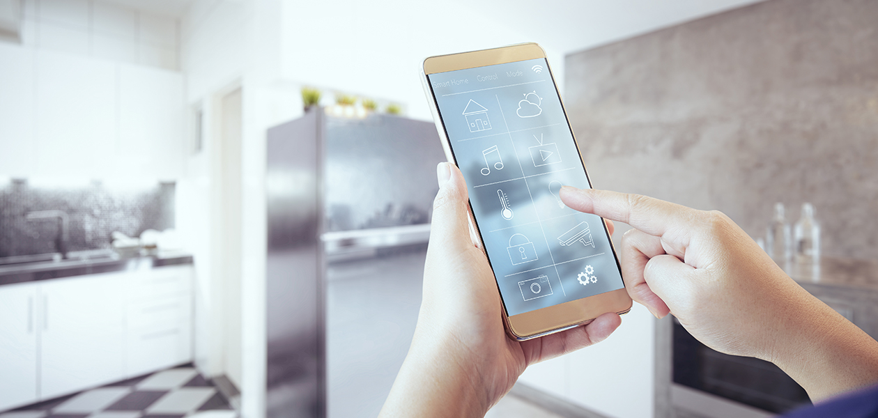 Styr alle de smarte produktene dine med Home Connect Hender som holder en smarttelefon foran et kjøkken.