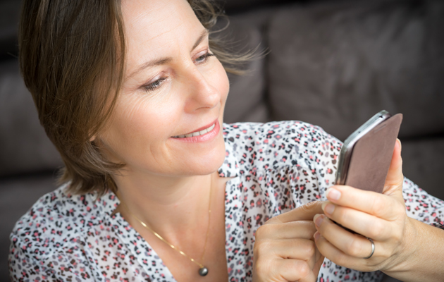 Ett smartprodukt og én app Kvinne som smiler mot mobilen.