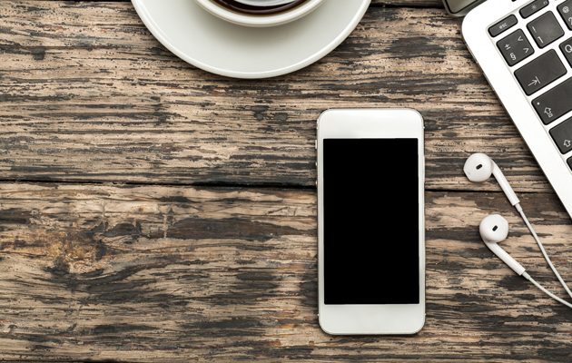 Bilde av et bord med iPhone, hodetelefoner og kaffekopp title.