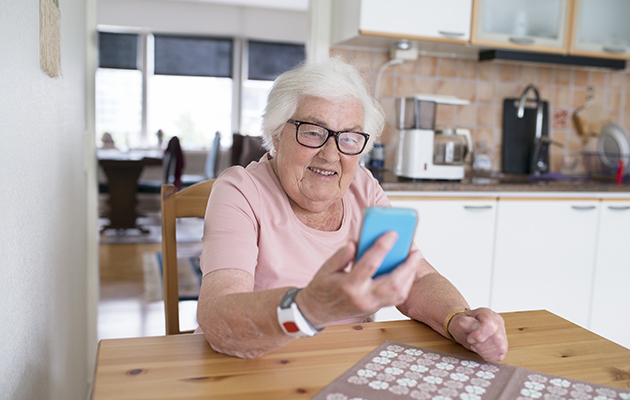 Velg fokusord En eldre dame holder en mobiltelefon