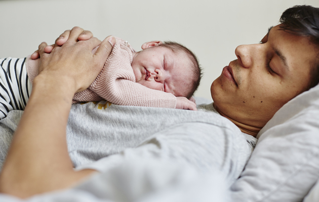 Hold temperaturen jevn Bilde av en mann med en liten baby på brystkassen