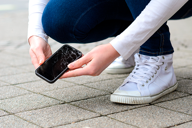Det skal ikke så mye til for å miste telefonen i bakken Person holder ødelagt telefon