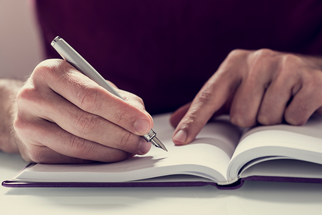 Appen Evernote Person skriver notater i en bok
