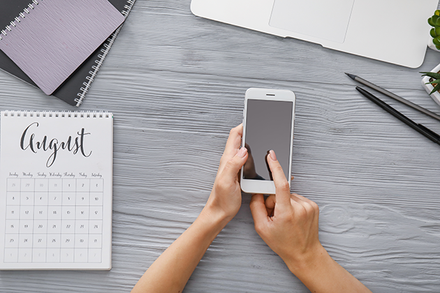 Appen myHomework student planner Kalender og telefon på et bord