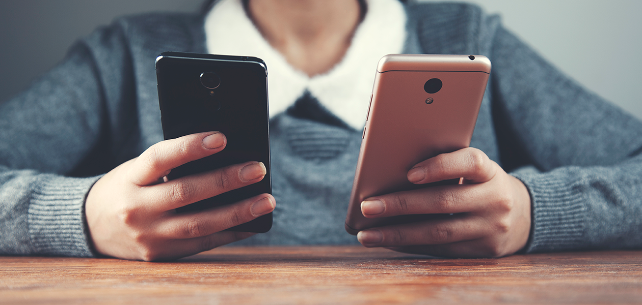 Å bytte til ny mobiltelefon trenger ikke være vanskelig Kvinne sitter med to mobiltelefoner