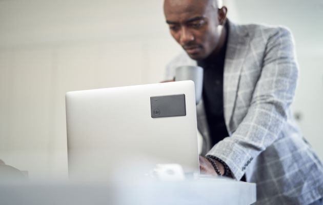 Tile Slim kan festes til bærbare PC-er og nettbrett med Tile-limputer En mann med en bærbar PC med Tile Slim
