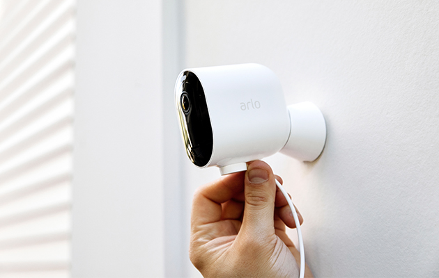 Du kan installere Pro 3 ledningsfritt på få minutter og montere det på vegger både ut og inne Arlo Pro 3 på vegg med hånd som holder ladeledning