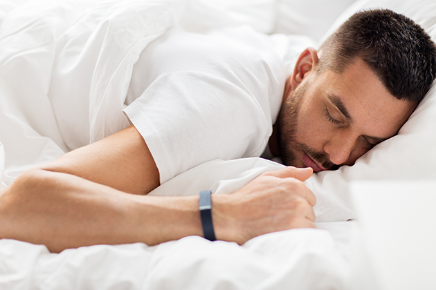Hva betyr en god natts søvn? Mann sover med smartklokke på