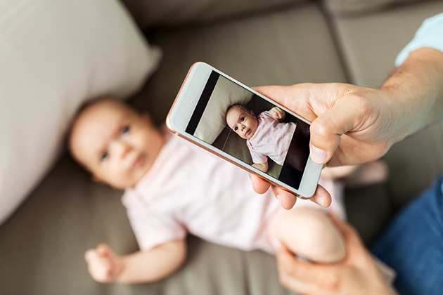 Hvilken funksjon er viktigst for deg? Mann tar bilde av baby med telefonen sin