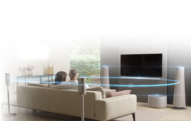 Opplev ekte hjemmekinolyd uten kabler. Par som ser TV med surroundanlegg fra Harmon Kardon
