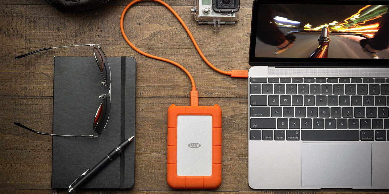 Diskopprydding og eksterne harddisker øker datamaskinens lagringsplass LACIE ekstern harddisk tilkoblet en Mac på et bord