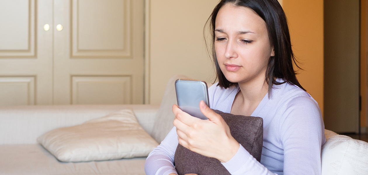 Beskytt mobilen din mot virus og malware Kvinne ser trist ned på telefonen sin