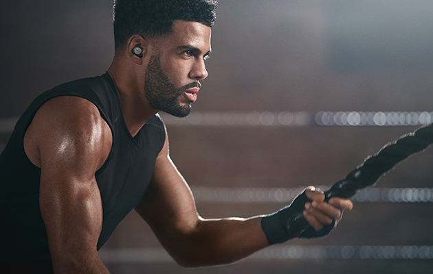 Jabra Elite Active 75t er vanntette ned til 1 meter og ideelle for treningsøkter i all slags vær Mann med Jabra Elite Active 75t i ørene som trener med tauer