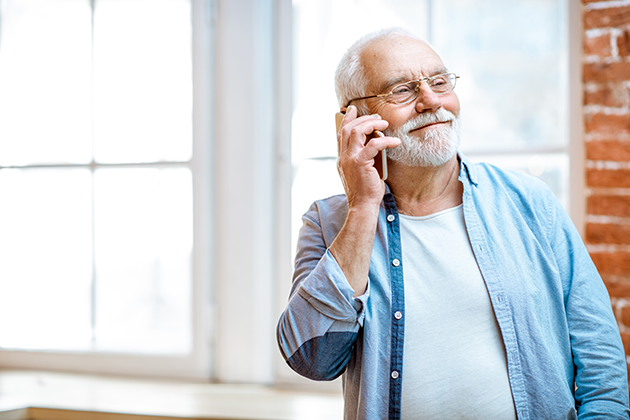 Slik velger du en brukervennlig telefon til seniorer Eldre mann med mobiltelefon