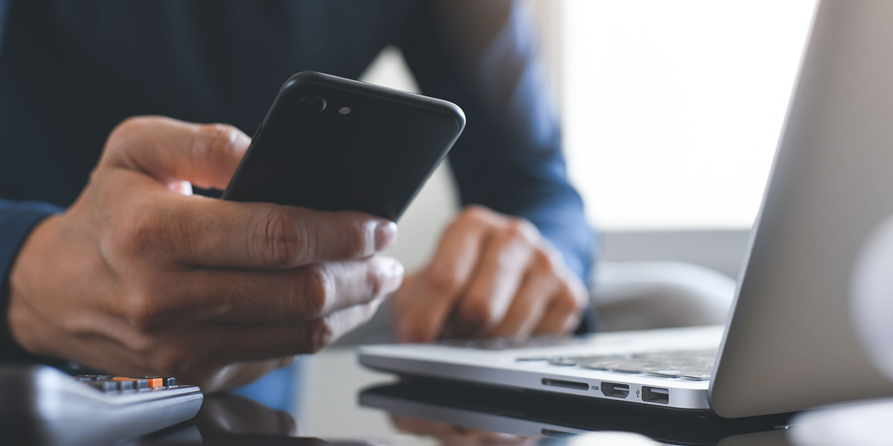 Bruk mobilen som wi-fi hotspot Mann sitter med PC og mobil