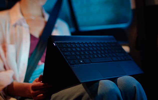 2-i-1 Kvinne i bil bruker en 2-i-1 HP Envy X360