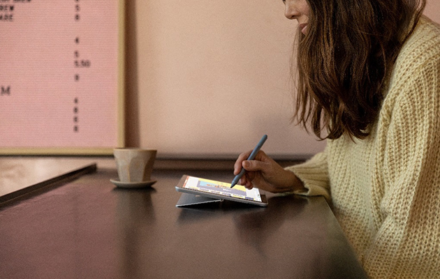 Surface Go 2 med 10,5 tommer stor skjerm gjør det enkelt å følge med Kvinne sitter med en Surface Pen i hånden og Surface Go 2