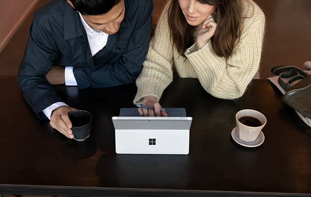 Surface Go 2 kan håndtere alle små og store gjøremål Mann og dame sitter med Surface Go 2 foran seg