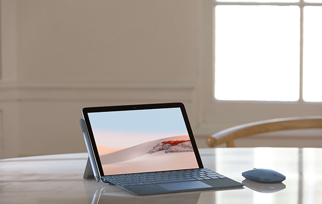Surface Go 2 har en større 10,5 tommers skjerm Surface Go 2 på et bord med Type Cover og Mobile Mouse