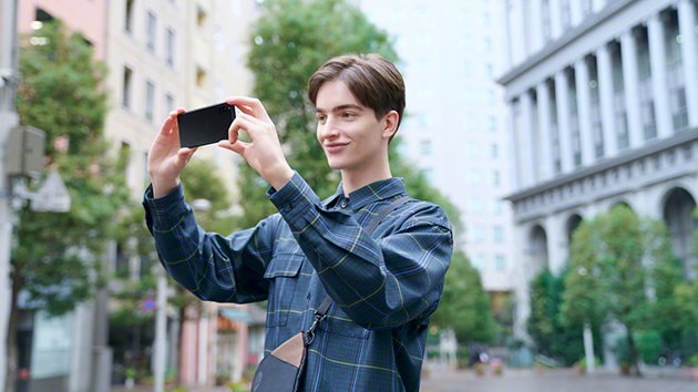 Tre kameraer, tre objektiver, utallige muligheter Sony Xperia 10 brukes av en ung mann til fotografering