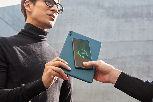 Gå aldri tom for strøm Mann holder Huawei MatePad Pro og lader annen persons telefon