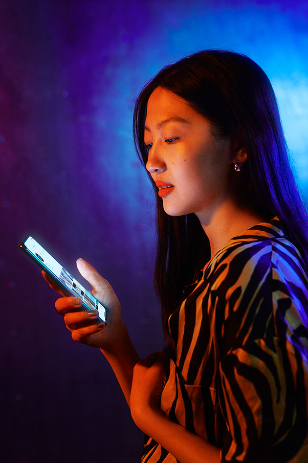 Opplev mer på den store AMOLED-skjermen OnePlus Nords skjerm lyser i hånden på en kvinne