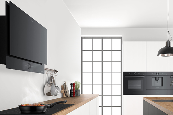 Bosch Carbon Black En vegghengt, flat kjøkkenvifte over en induksjonstopp i et kjøkken