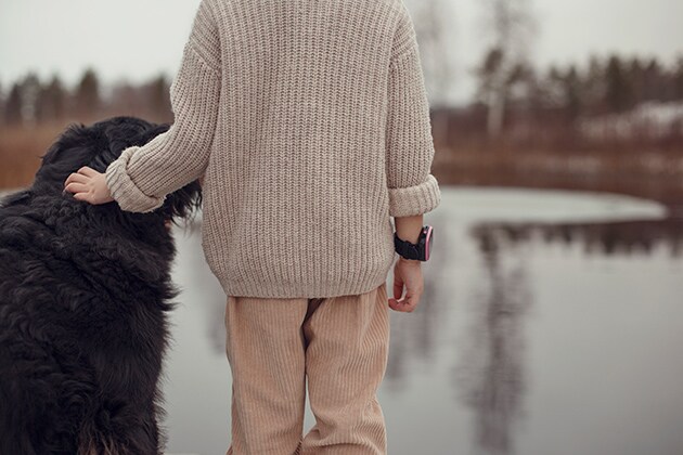  Xplora 5X Play på et barn som står sammen med en hund
