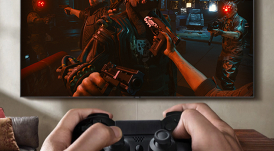Inngangsforsinkelsen på Samsung QLED TV er så lav som 10 ms Person som gamer foran TV