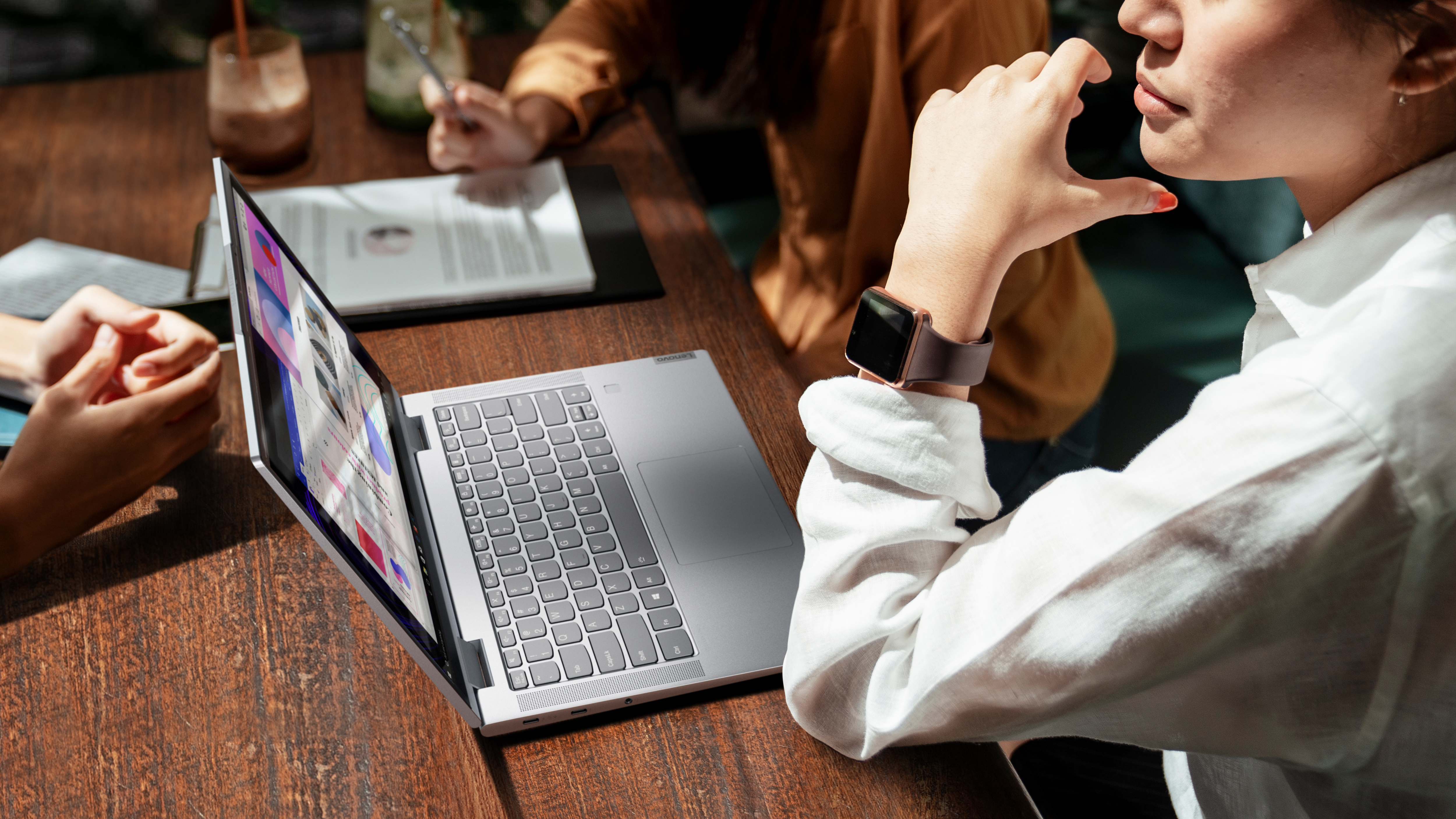 Lenovo Yoga 7i Kvinne sitter på huk med en Yoga 7i foran seg