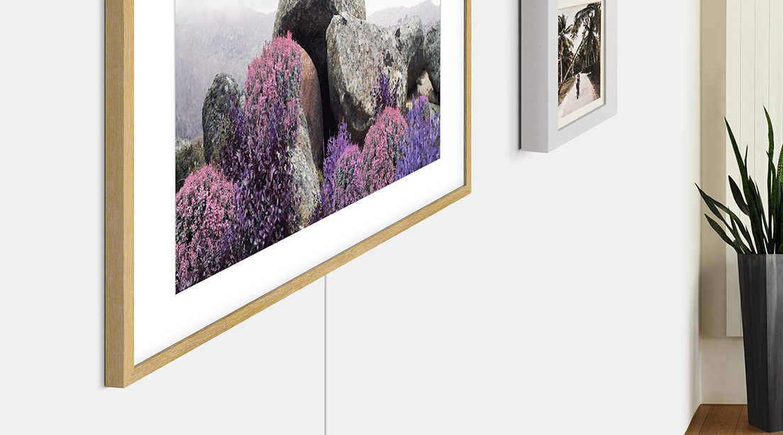 The Frames slanke design gjør TV-en til et flott supplement til rommet The Frame ved siden av bilde på vegg
