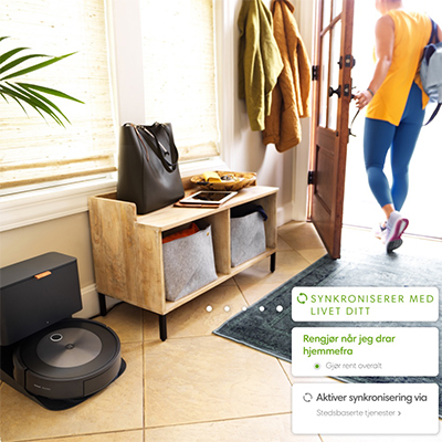 Roomba® j7/Roomba® j7+ -robotstøvsuger En svart robotstøvsuger i et hverdagsrom og en smarttelefon