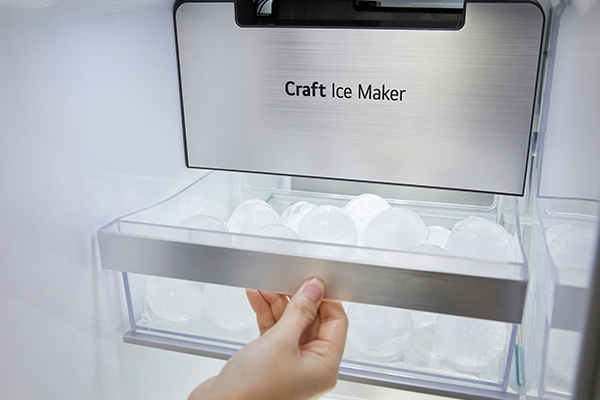 LG Craft Ice - perfekte isbiter hjemme En hånd som drar ut en kjøleskapsskuff full av is