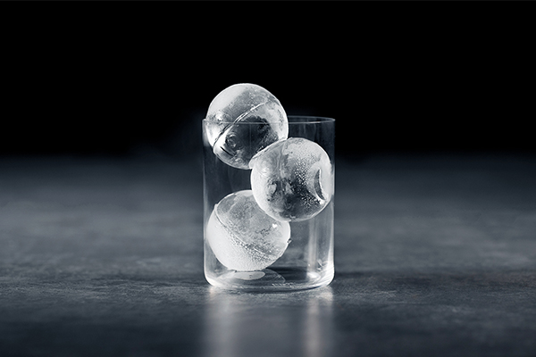 LG Craft Ice - perfekte isbiter hjemme Et glass med tre runde isbiter i på en svart bakgrunn