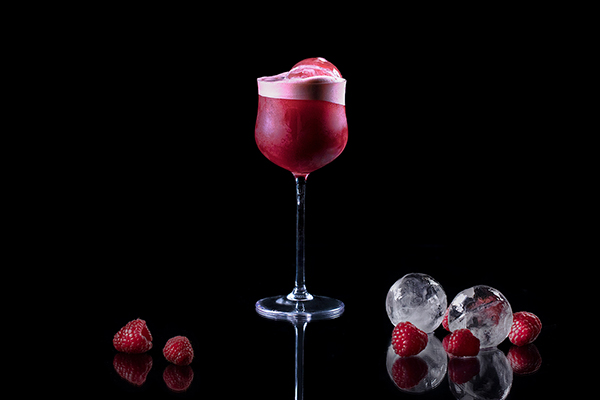 LG Craft Ice - perfekte isbiter hjemme Rød drink med iskuler i med bringebær og iskuler ved siden av, på svart bakgrunn