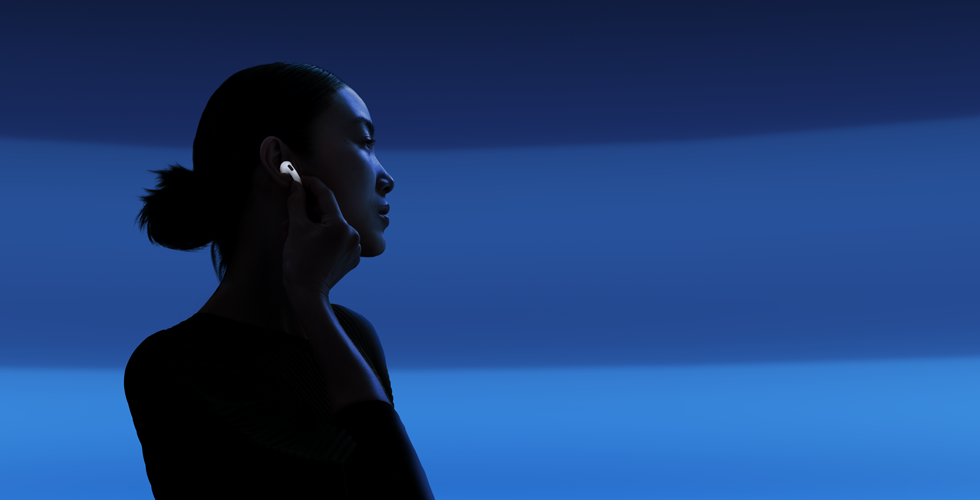 En person som holder i stilken på AirPods 5 med tommel og pekefinger for å bytte lyttemodus