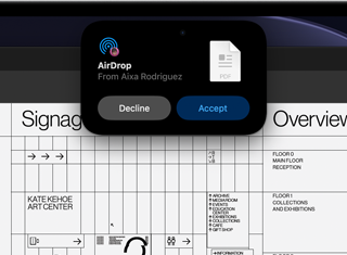 Dynamic Island vises på skjermen med en AirDrop-forespørsel i et lite vindu over en åpen Adobe Acrobat-fil