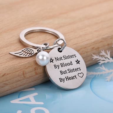 Nøkkelring med vinge og merke med teksten ""Sisters by Heart""
