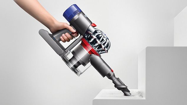 En hånd bruker Dyson V8-støvsugeren uten stang