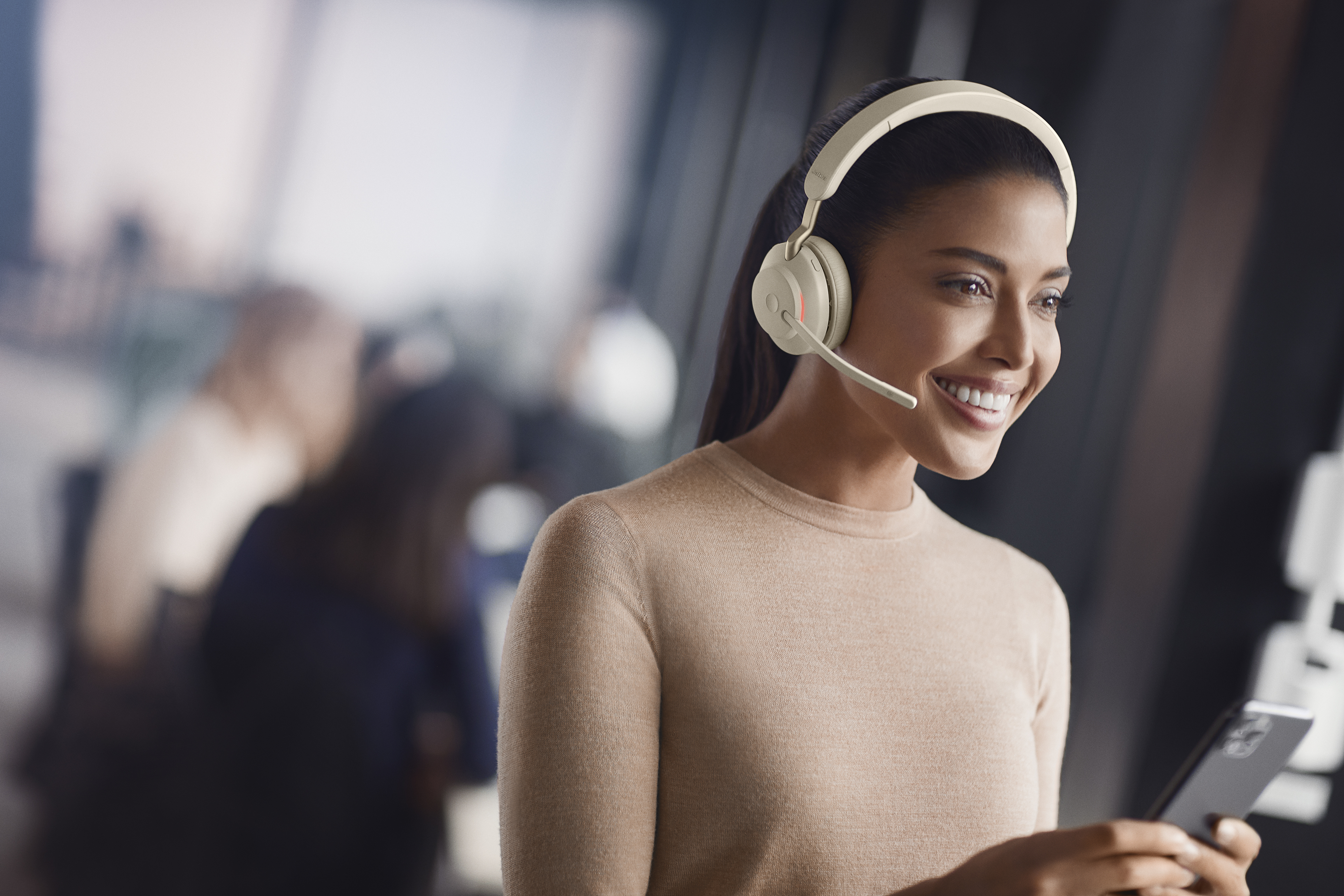 Kvinne på kontor med beige Evolve2 65-headset