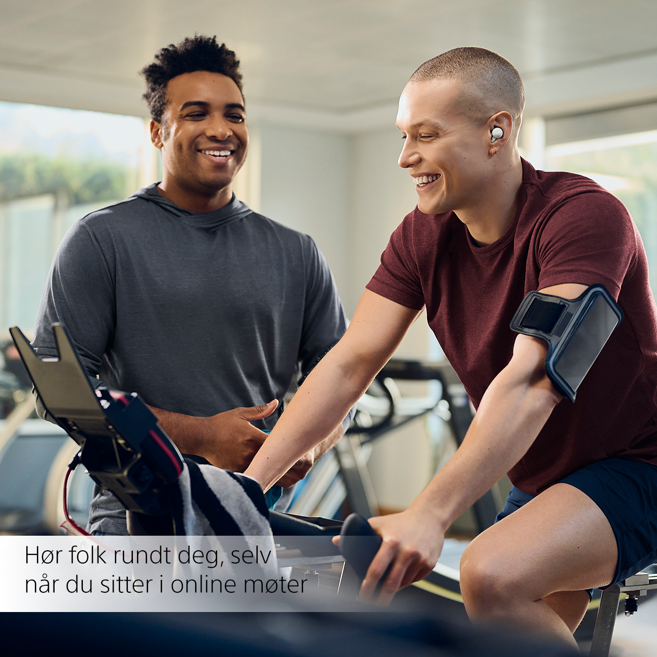 Man on exercise bike laughing with another man