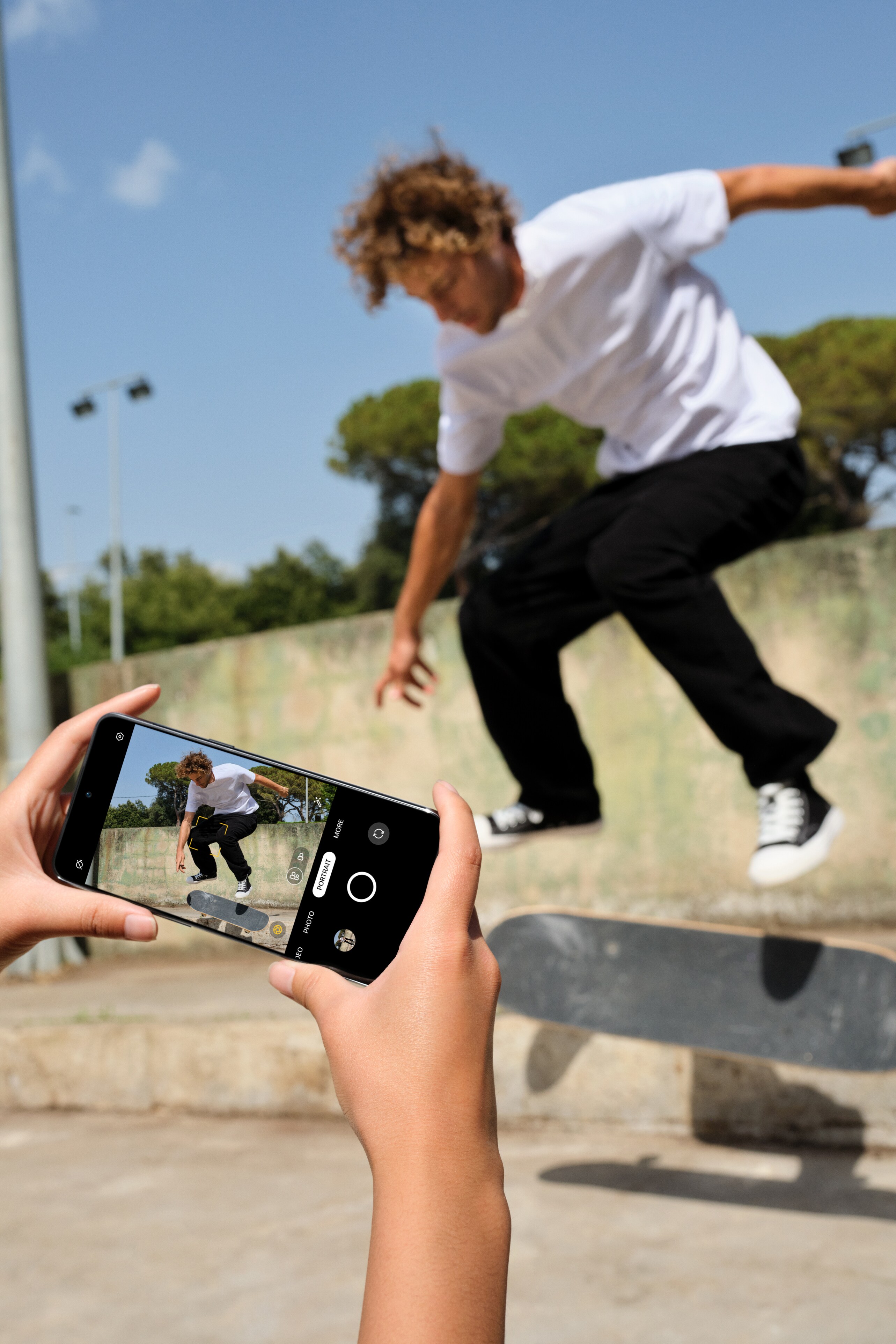 Person som filmer en gutt på skateboard med OnePlus 10T