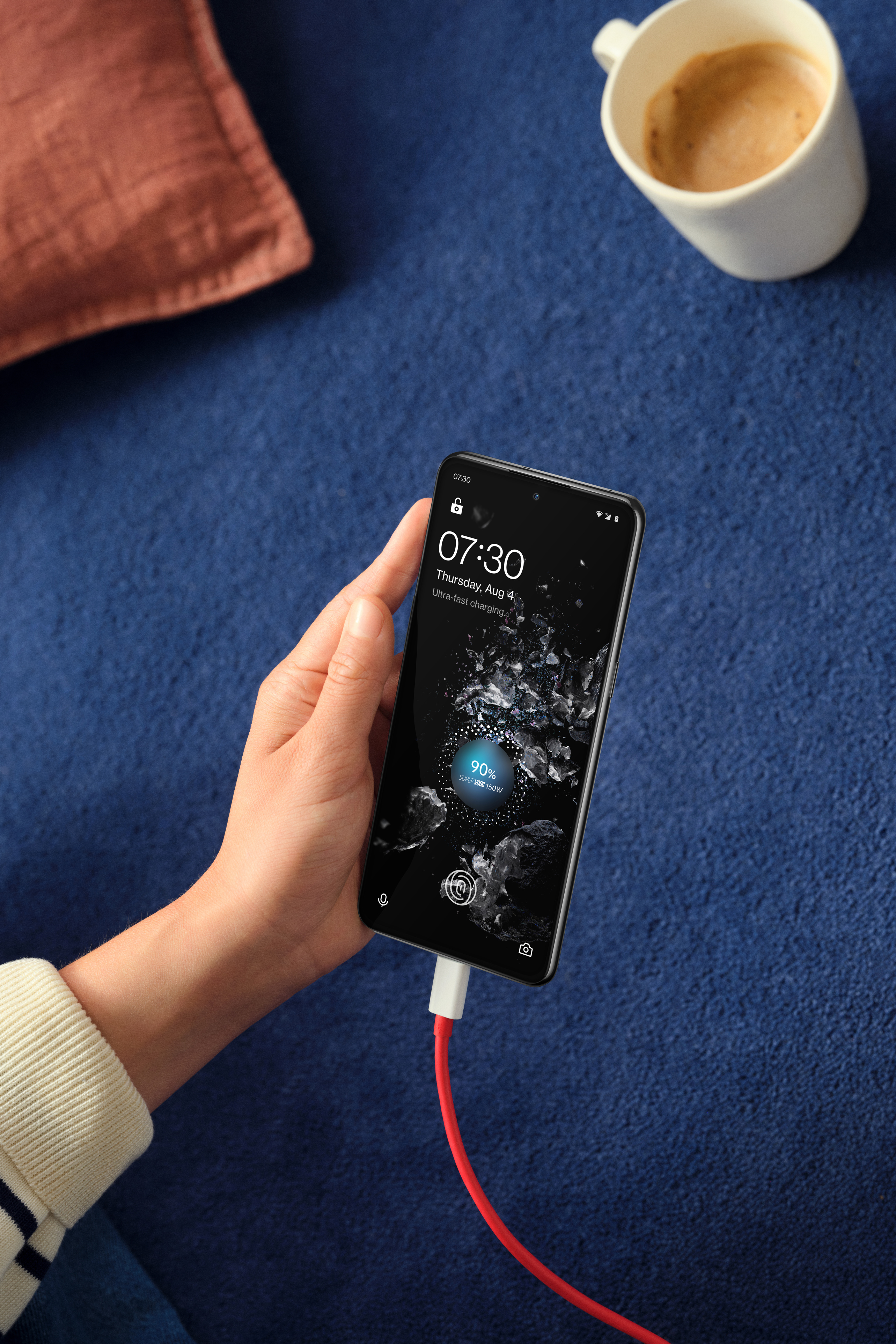 OnePlus 10T telefonlader og kaffekopp i bakgrunnen