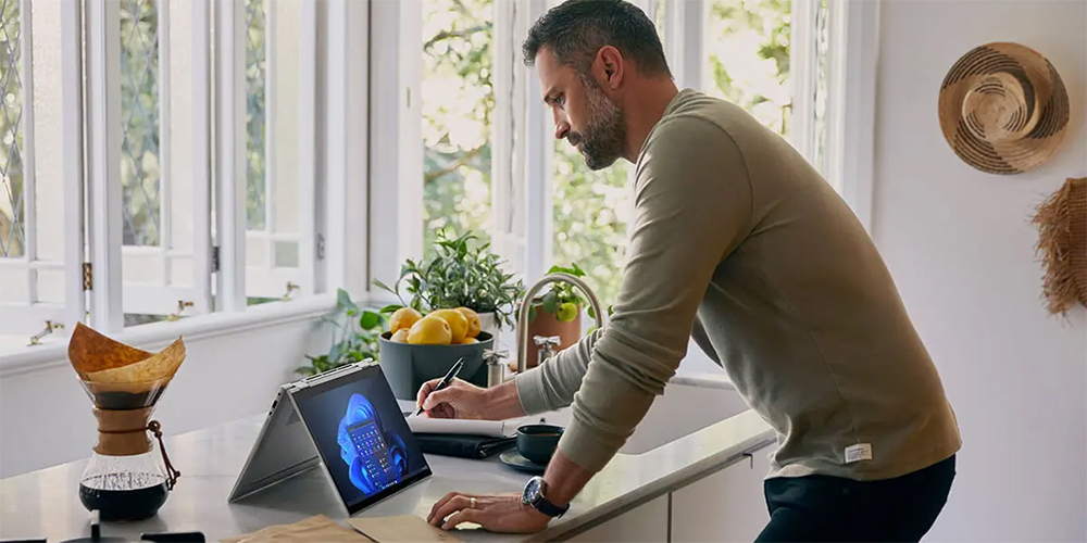 Mann på en kjøkkenøy foran en sammenbrettet HP EliteBook